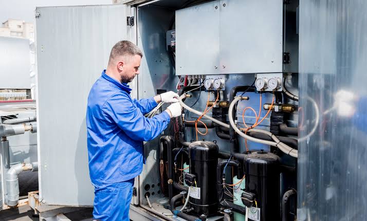 Technician performing HVAC service on commercial mechanical equipment