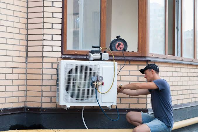 Technician installing a residential outdoor air conditioning condenser