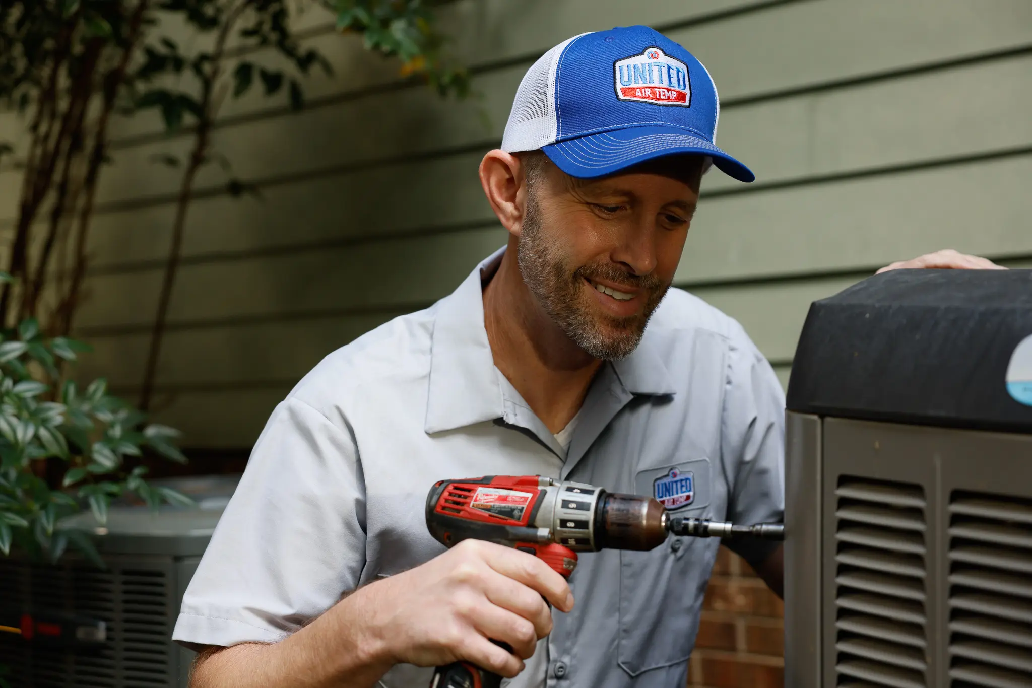HVAC technician servicing an outdoor residential condenser