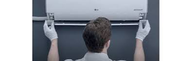 Technician installing a wall-mounted indoor air conditioning unit